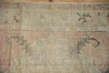 Low pile texture of a vintage Oushak rug in dusty rose, silver, and charcoal.