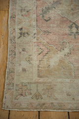 Worn, low pile and silver border on the corner of a distressed Turkish Oushak rug.