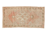 Distressed vintage Oushak runner with a floral medallion in faded dusty rose, olive green, and soft platinum.