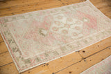 Full view of a distressed Oushak runner in time-softened dusty rose and olive green tones.