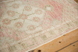 Worn hand-knotted pile and floral vine border in dusty rose and dusty olive green.
