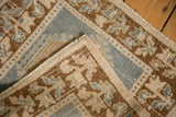 Distressed hand-knotted Oushak rug showing worn pile texture and intact selvage.