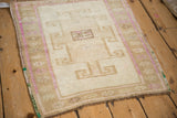 Distressed Kars rug corner, close-up of geometric-floral main border with faded magenta.
