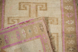 Distressed Kars rug close-up, showing faded magenta pile texture and hand-knotted reverse side.