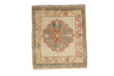 Distressed vintage Oushak square rug with a scalloped medallion in dusty green, red, and gold.