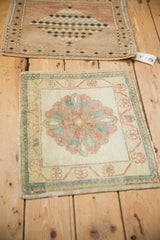 Two small vintage Turkish rug mats, one featuring a floral Oushak design and the other a geometric pattern.