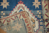 Vintage Distressed Oushak rug folded corner, revealing hand-knotted texture, dusty blue field, and selvage.
