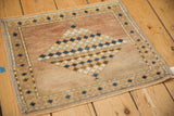 Distressed Oushak rug's worn pile texture and narrow seed-patterned border in muted tones.