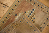 Distressed Oushak rug corner showing worn dusty mauve pile, tight hand-knotted foundation, and blue motifs.