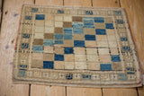 Textured detail of the vintage Oushak rug's plant-motif border and distressed blue squares.