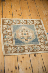 Side selvage and germinating plants border of vintage Oushak rug with even wear, dusty blue, beige tones.
