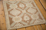 Close-up of distressed vintage Oushak rug texture with pale coffee stepped motifs and serrated florals.