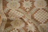 Hand-knotted distressed wool pile, revealing stepped geometric motifs in coffee and ivory.