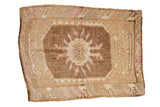 Vintage distressed Kars square rug with a central floral medallion in coffee brown and faded purple.