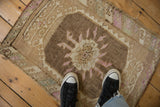 Even wear and low-pile texture of a distressed Kars rug with a brown and purple medallion.