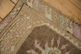 Stylized serpent border in coffee brown and faded purple with an even, low-pile texture.