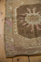 Close-up on the serpent stylized border and distressed low pile of a vintage Turkish Kars rug.