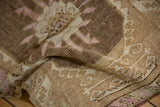 Textured, even wear across the hand-knotted pile of a vintage Kars rug in brown and purple hues.
