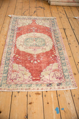 Distressed pile and ivory corner spandrel on a vintage Oushak rug runner.