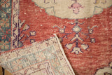 Textured cherry red distressed Oushak rug pile revealing its sturdy hand-knotted reverse.