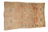 Distressed vintage Oushak rug, faded central medallion in sand, dusty gold, and muted raspberry, 2'9