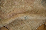 Distressed vintage Oushak rug with abraded texture, soft gold and faded rose hues.