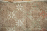 Close-up of distressed pile on vintage Oushak rug, showing soft fern blossom and starburst motifs.