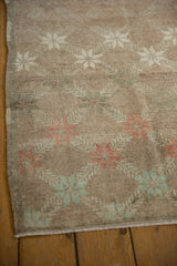 Distressed Oushak rug texture with faded mint green and terracotta starbursts.