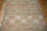 Distressed texture and worn pile of a vintage Oushak rug with faded starburst motifs.