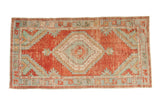 Vintage Oushak runner rug with a distressed cherry red field and a geometric seafoam green medallion.
