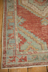 Stepped corner spandrel and meandering vine border of a distressed vintage Turkish Oushak rug.