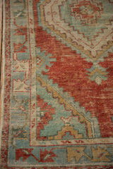 Stepped geometric spandrel in cherry red and seafoam green on a distressed hand-knotted Oushak rug.