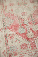 Distressed vintage Oushak runner texture, with soft pink, ivory, and faded turquoise floral motifs.