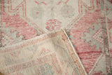 Distressed Oushak rug, close-up of low pink pile with ivory tones and hand-knotted reverse.