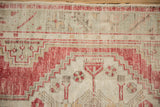 Worn, low-pile knots of a vintage Oushak rug with a cherry red and sand geometric motif.