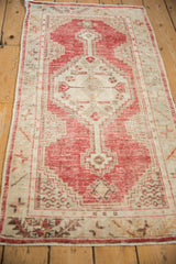 Angled view down the length of the distressed Oushak runner showing its geometric pattern.