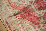 Soft, worn texture of a hand-knotted Oushak runner with cherry red geometric details.