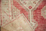A corner of the vintage Oushak rug folded to show its hand-knotted foundation.