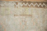 Shaggy distressed pile and coffee brown zig-zag vine border of a vintage Turkish Tulu rug.