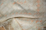 Close-up on the soft, nubby pile of a distressed Tulu rug showing ivory and orange knots.