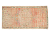 Distressed Oushak runner with a roundel floral bouquet in dusty blush, pink, and faded teal.