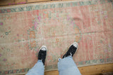 A vintage distressed Oushak rug showing its soft, worn texture underfoot.