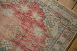 Distressed Oushak corner, showing worn knot heads, abrashed dusty rose, ivory, and teal patterns.
