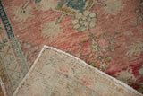 Vintage distressed Oushak rug's dusty rose and ivory pile with its hand-knotted reverse.