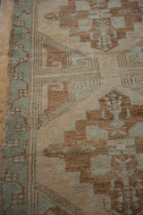 Distressed vintage Oushak runner border with faded seafoam and coffee brown geometric patterns.