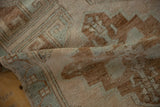 Vintage distressed Oushak runner with textured pile, dusty green, copper, and ivory geometric pattern.