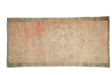 Vintage distressed Oushak rug runner with a faded floral medallion, abrashed rose field, and dusty teal border.