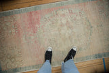 Decorative low pile and time-softened texture of a vintage Oushak runner with rose and teal accents.