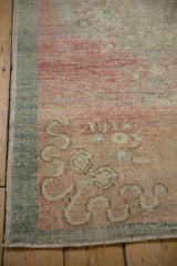 Intact side cord selvage on a distressed Oushak runner with a worn, hand-knotted texture.