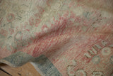 The low pile and hand-knotted texture of a distressed Oushak runner in dusty rose and teal.